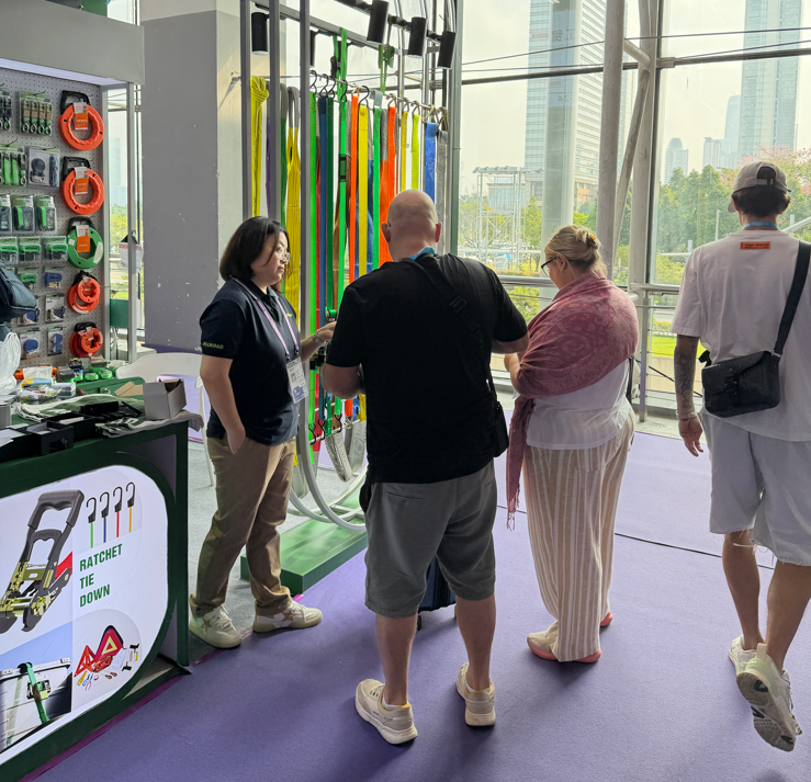 An ALLROAD team member presents ratchet tie-down straps to visiting buyers at the booth