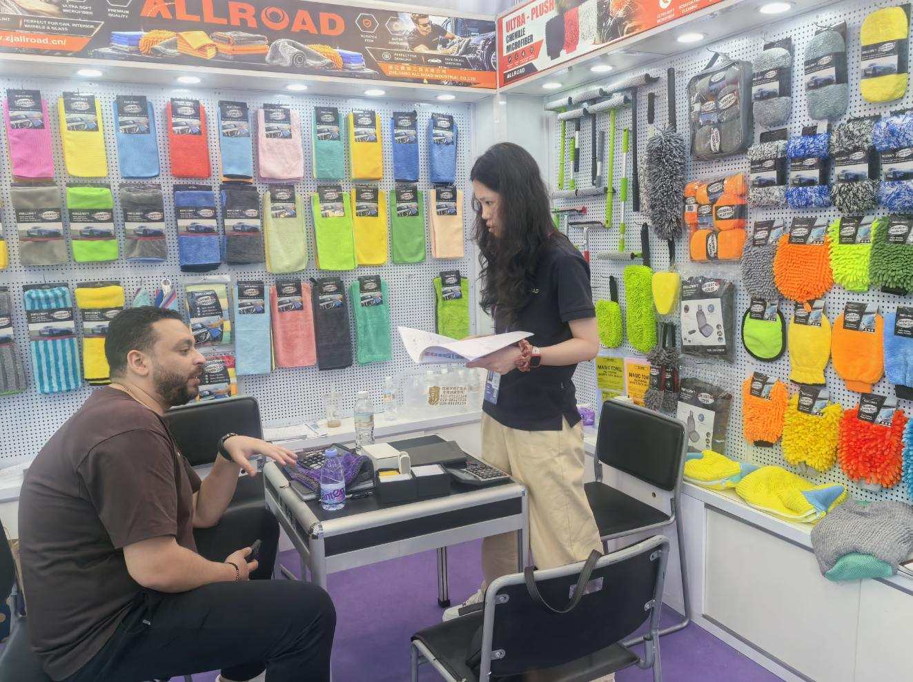An ALLROAD team member discussing microfiber car-care products with a buyer